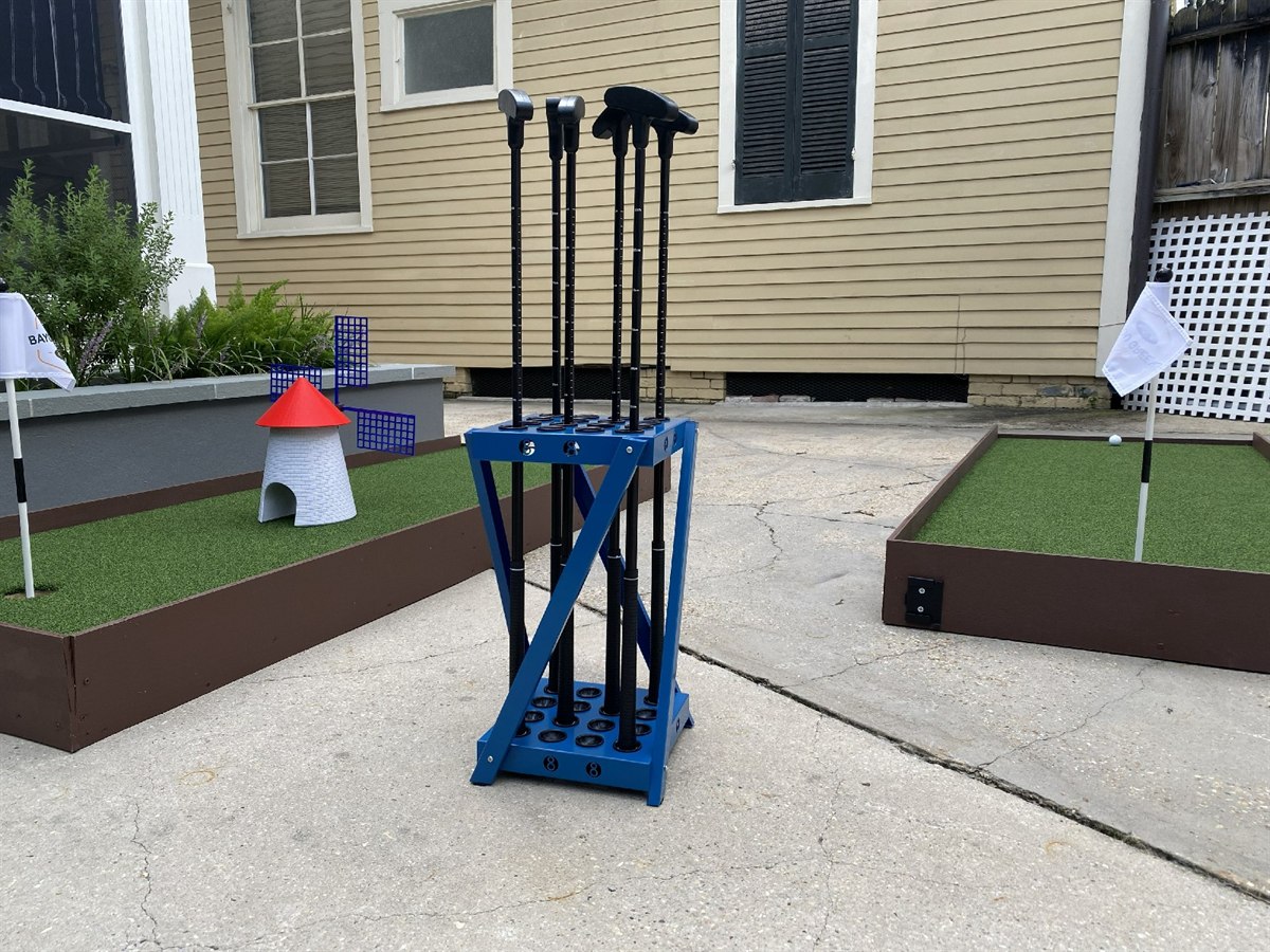 Putter caddie with clubs beside a mini-golf hole