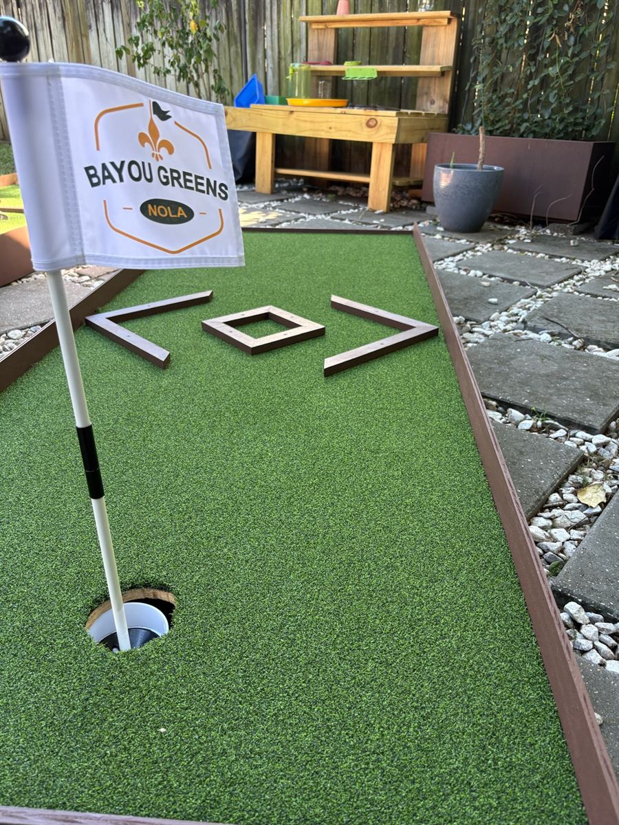 Bayou Greens NOLA flag over a mini-golf hole with a diamond bumper obstacle